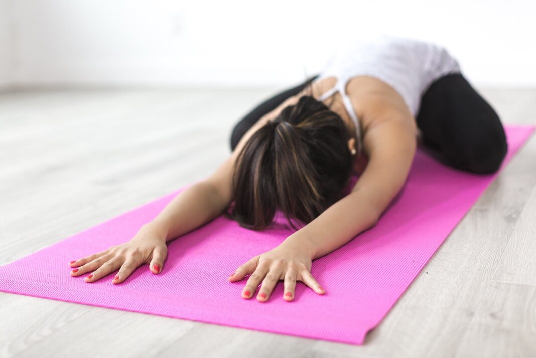 Teilnehmerin genießt entspannt ihr kostenloses Yoga-Probetraining im modernen Studio.